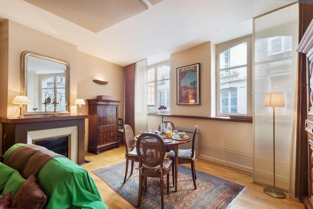 un salon avec une table et une cheminée dans l'établissement Bayonne - Cathedrale & Halles - Centre ville, à Bayonne