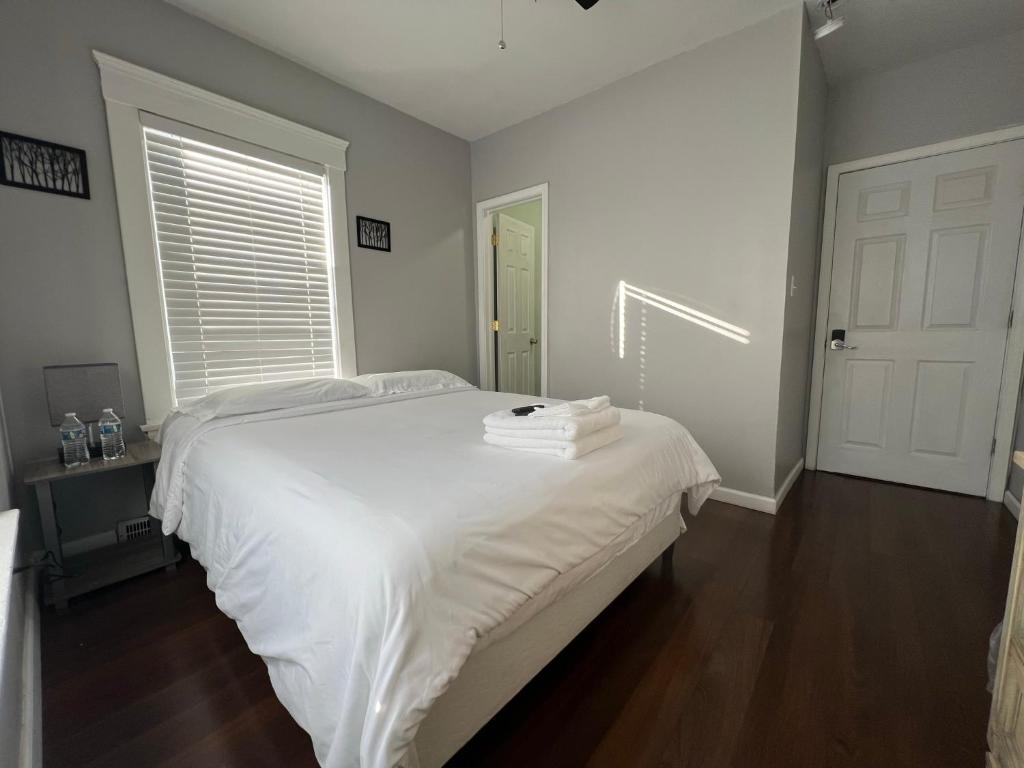 een slaapkamer met een bed met witte lakens en een raam bij Stay with Jay in Cleveland 3 in Cleveland