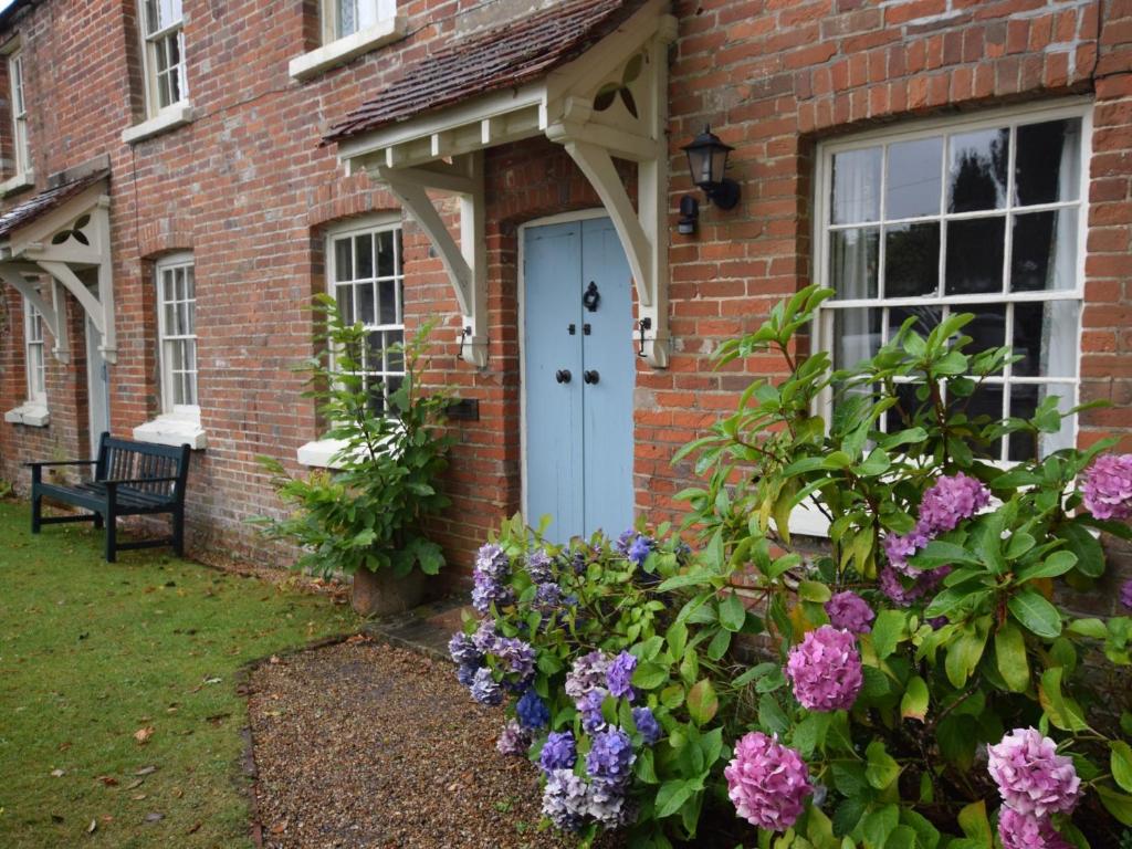 a brick house with a blue door and flowers at 4 bed in Lyndhurst 57407 in Lyndhurst