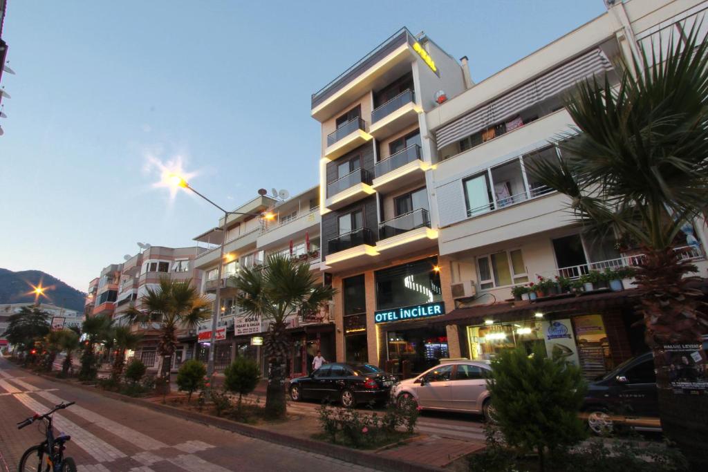 a street with cars parked in front of a building at Inciler Hotel in Altınoluk