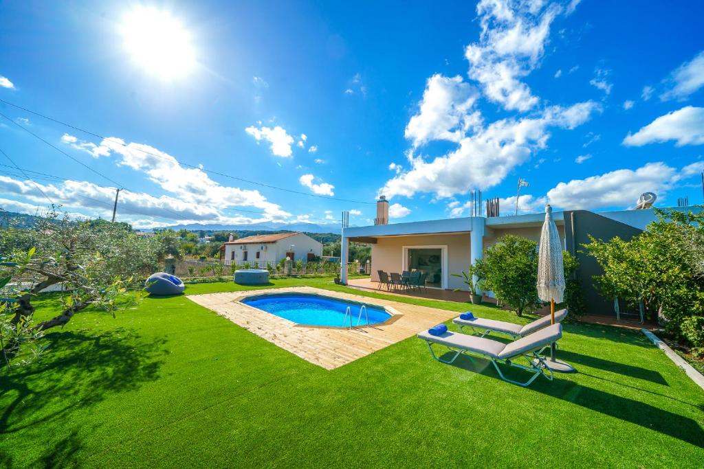 a yard with a swimming pool and a house at Private Villa Lima in Chania with Pool & Hot Tub in Vamos