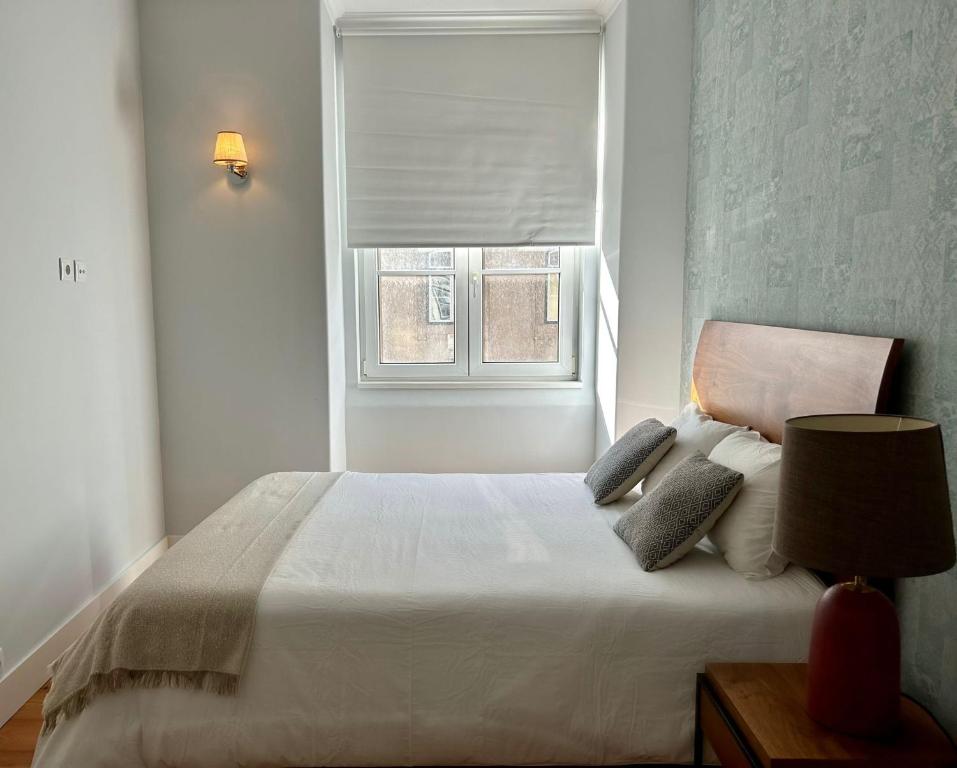 um quarto com uma cama branca e uma janela em Casa da Prata em Lisboa