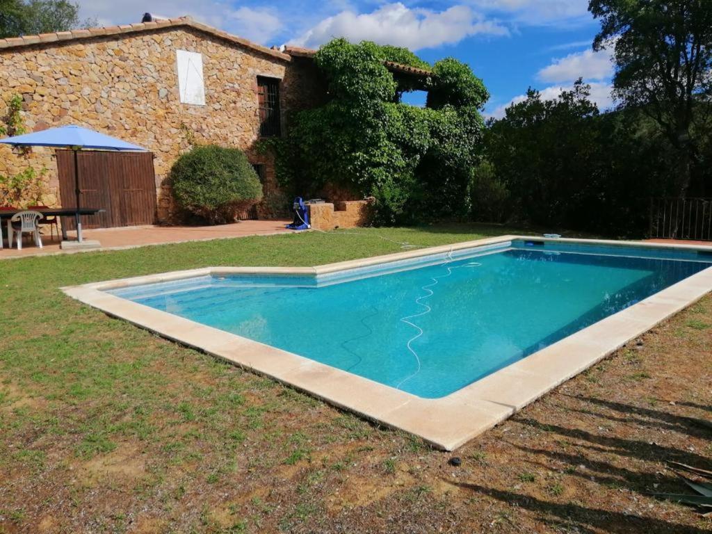 einen Pool im Hof eines Hauses in der Unterkunft Masia Rustica Costa Brava in Calonge