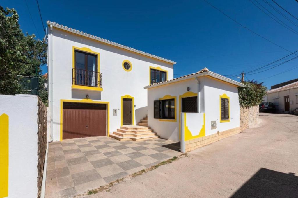 a white and yellow house with a driveway at Casa Bellarosa in Raposeira
