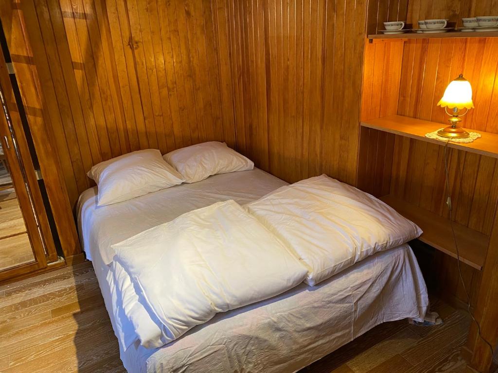 - un petit lit dans une chambre en bois avec une lampe dans l'établissement Quatre rêves à Lutèce, à Paris