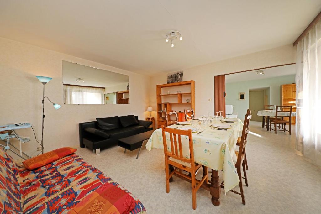 een woonkamer met een tafel en een eetkamer bij Découverte - Appt avec vue montagne in Gérardmer