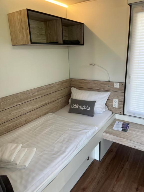 Cama en habitación pequeña con almohada en Hostel Stover en Löningen