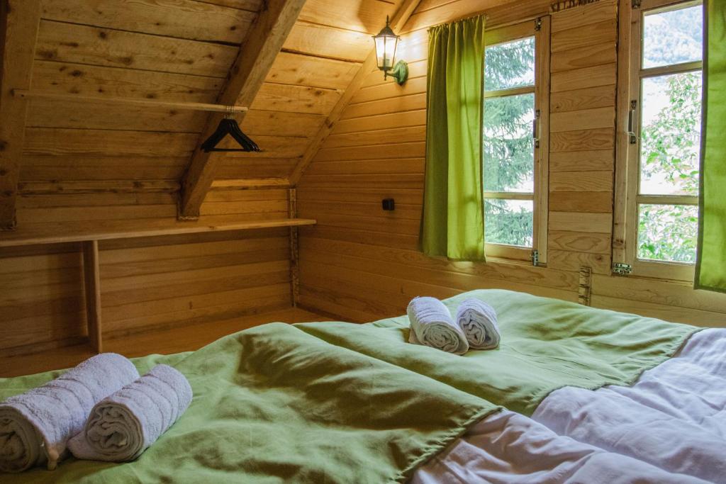 ein Schlafzimmer mit einem Bett mit gerollten Handtüchern darauf in der Unterkunft Mestia Eco Huts 2 in Mestia