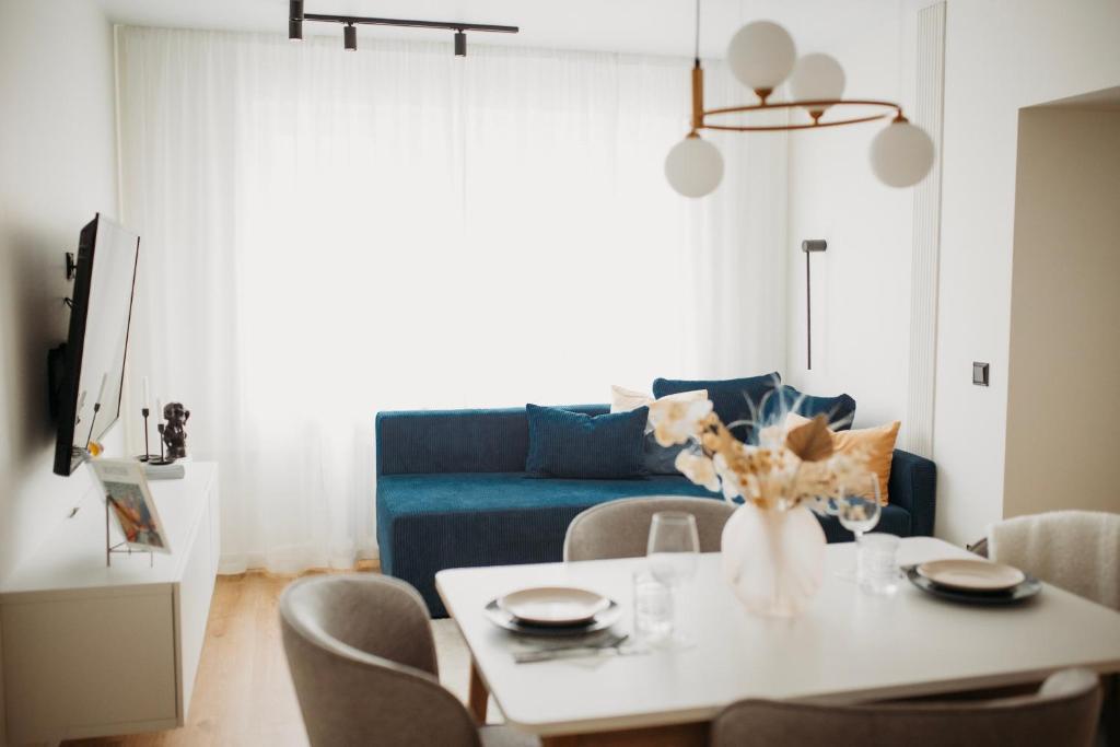 uma sala de estar com uma mesa e um sofá azul em Two-Story Urban Gem em Talin