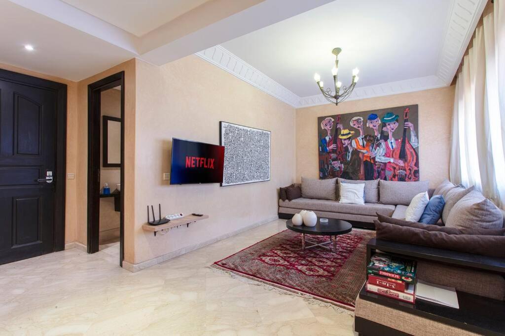 een woonkamer met een bank en een tv bij Palette of Dreams - Marrakech Centre in Marrakesh