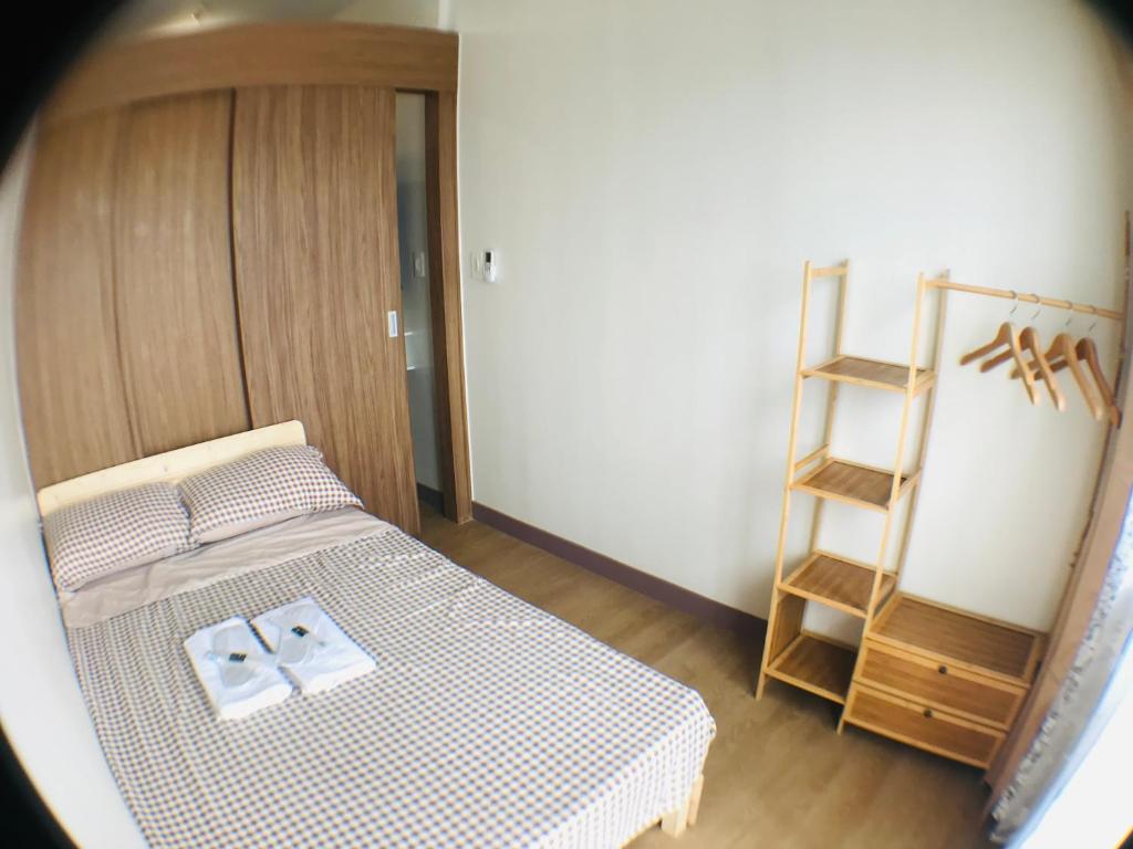 Habitación pequeña con cama y escalera en Spring Residences Affordable Staycation Bicutan Paranaque near NAIA Airport, en Manila