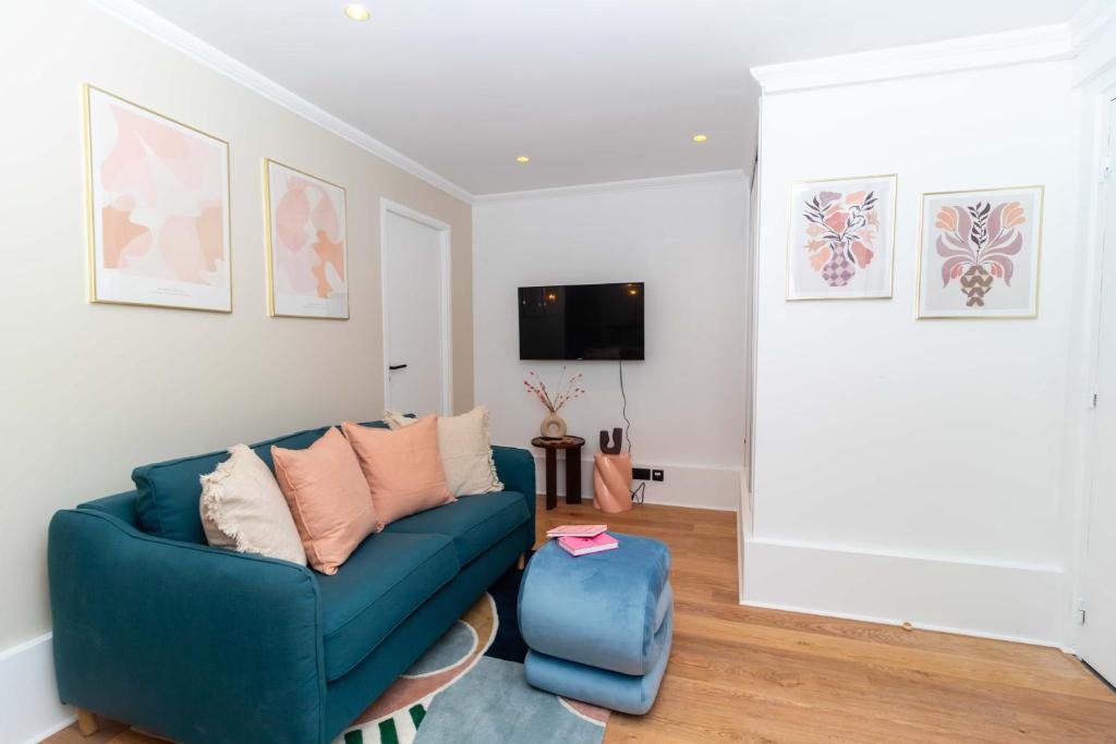 un salon avec un canapé bleu et une télévision dans l'établissement Apartment Center of Paris Le Marais by Studio prestige, à Paris