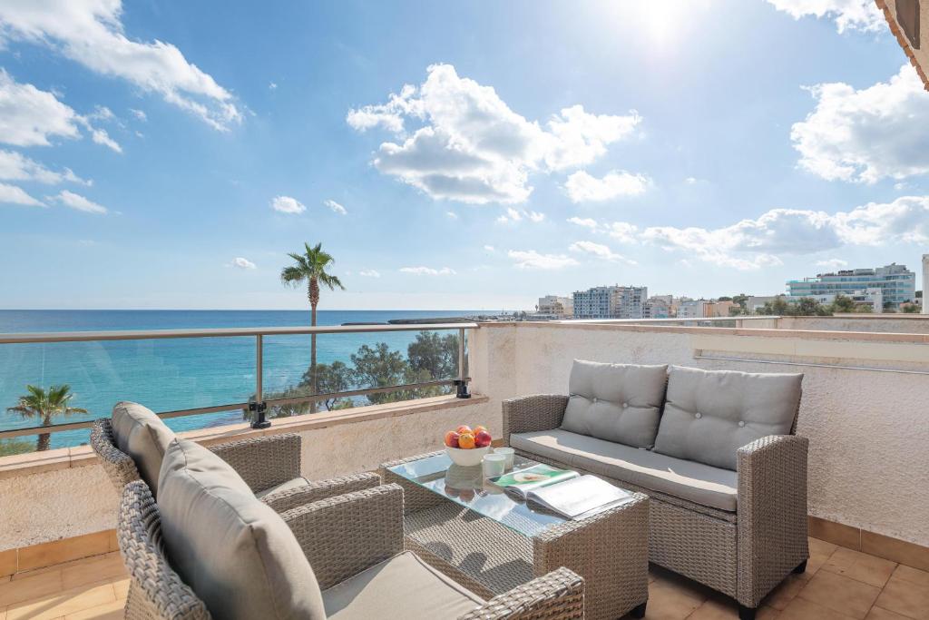 a balcony with chairs and a table and a view of the ocean at Antic 202 in S'Illot