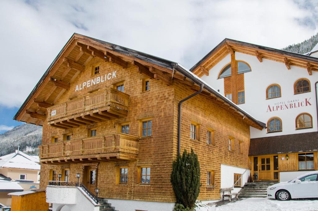 a large wooden building with a balcony at Hotel Garni Alpenblick in Ischgl