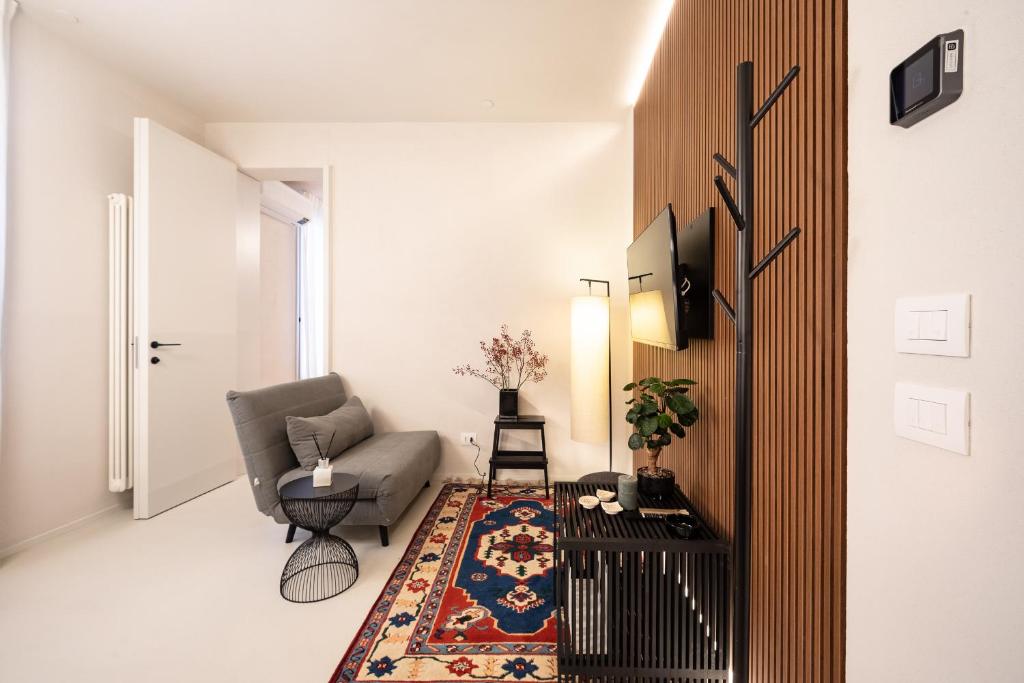 uma sala de estar com um sofá e uma cadeira em Verona Liberty Flats - Torricelle e Adige em Verona