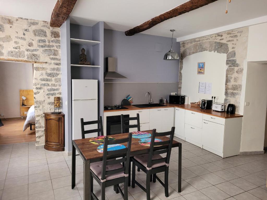 a kitchen with a table and chairs in a room at Souvenirs d'hier in Hyères