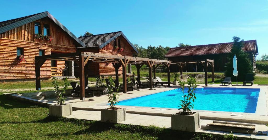 une maison avec une piscine dans la cour dans l'établissement Timber Fairies, à Slunj