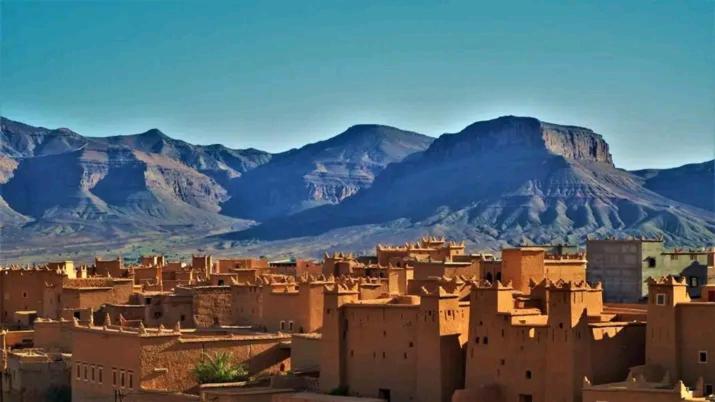 a group of buildings with mountains in the background at La perle de saghro in Nkob