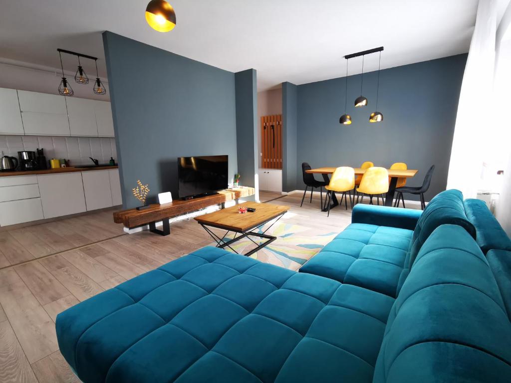 a living room with a blue couch and a table at Serenity Suite in Sinaia