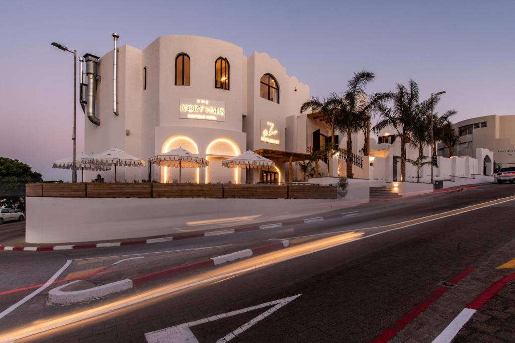 un edificio al lado de una calle por la noche en The Ivory Haus, en Plettenberg Bay