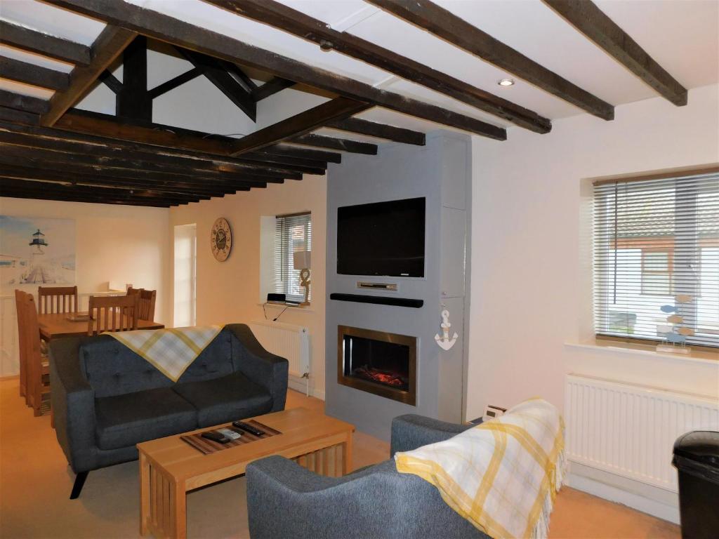 a living room with a couch and a fireplace at Anchor Cottage, Sheringham - Keys Holiday Cottages in Sheringham