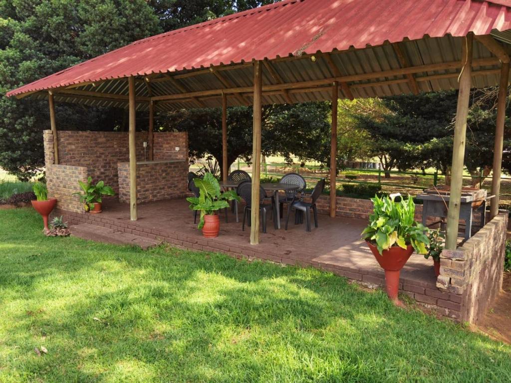 un pabellón con una mesa y sillas en un patio en Lunford Garden Cottage, en Rayton