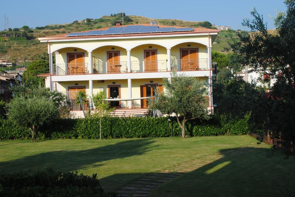 uma grande casa branca numa colina com um quintal em Larus Hotel em Sangineto