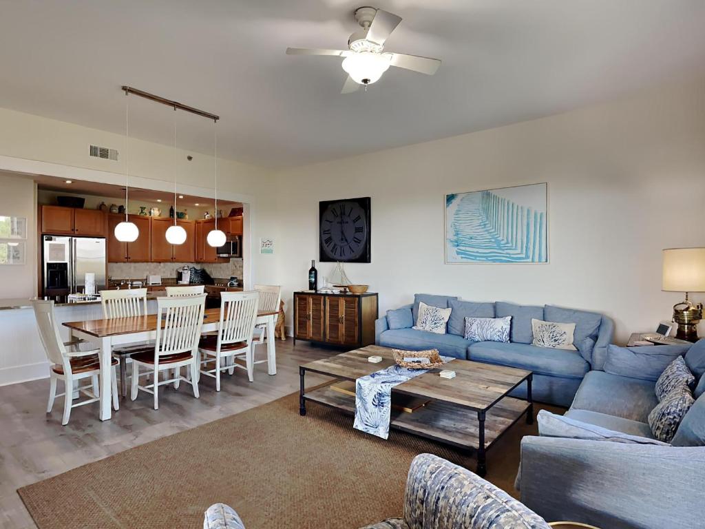 a living room with a blue couch and a table at Redfish Village m2-430 in Blue Mountain Beach