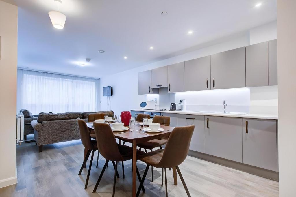 een keuken en eetkamer met een tafel en stoelen bij Luxury 2 bed flat in a new block in East Acton in Londen
