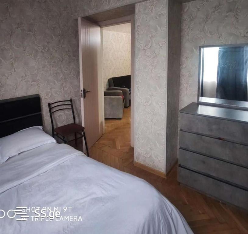 - une chambre avec un lit et une commode avec une télévision dans l'établissement apartment, à Tbilissi