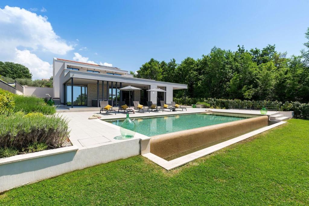 Rajki的住宿－Villa Damian，庭院中带游泳池的房子