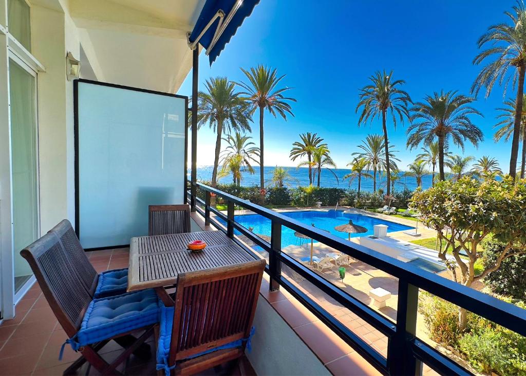 マルベーリャにあるSkol 2A Amazing 2 Bedroom Apartment Skol Marbellaの海の景色を望むバルコニー(テーブル、椅子付)
