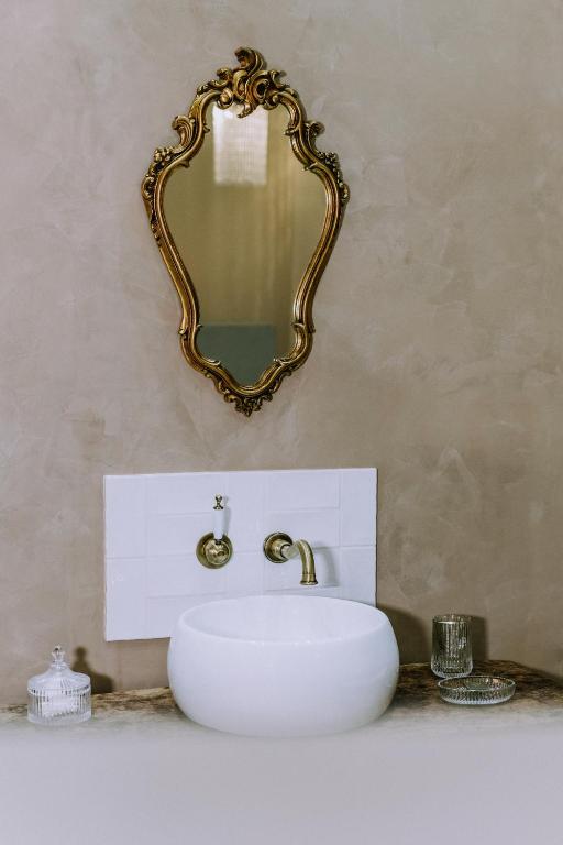 une salle de bain avec un lavabo blanc et un miroir dans l'établissement Maison Guy, à Saint-Bauzély