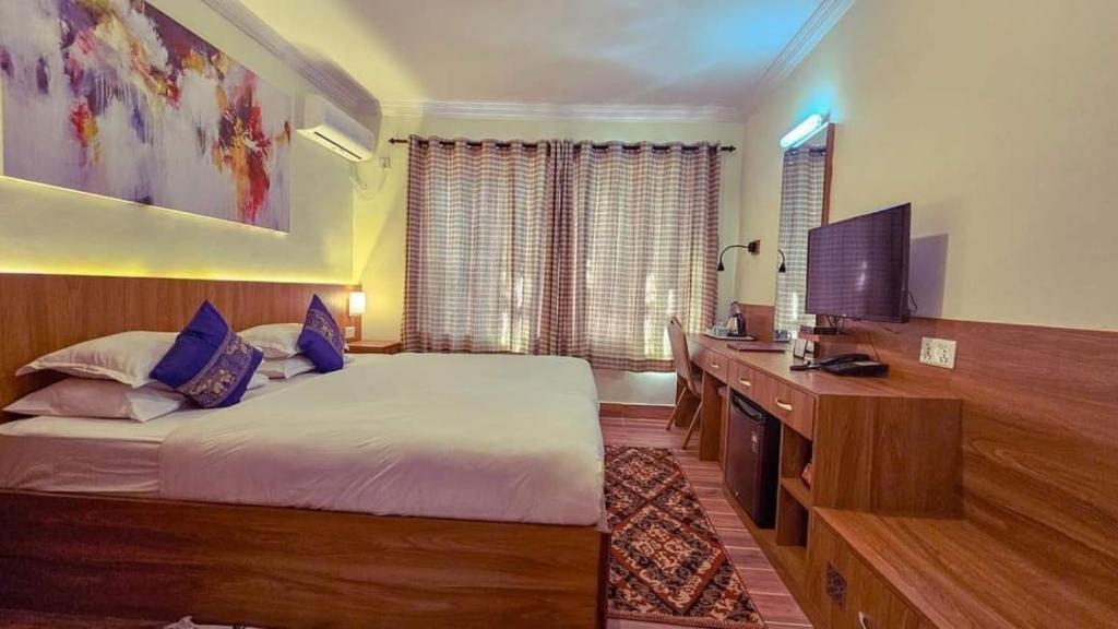 a bedroom with a bed and a flat screen tv at Chef House Resort in Kathmandu