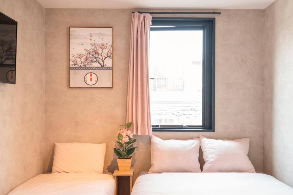 twee bedden in een kamer met een raam bij New Designed apart ment Shin-Okubo Sta 3 min walk in Tokyo