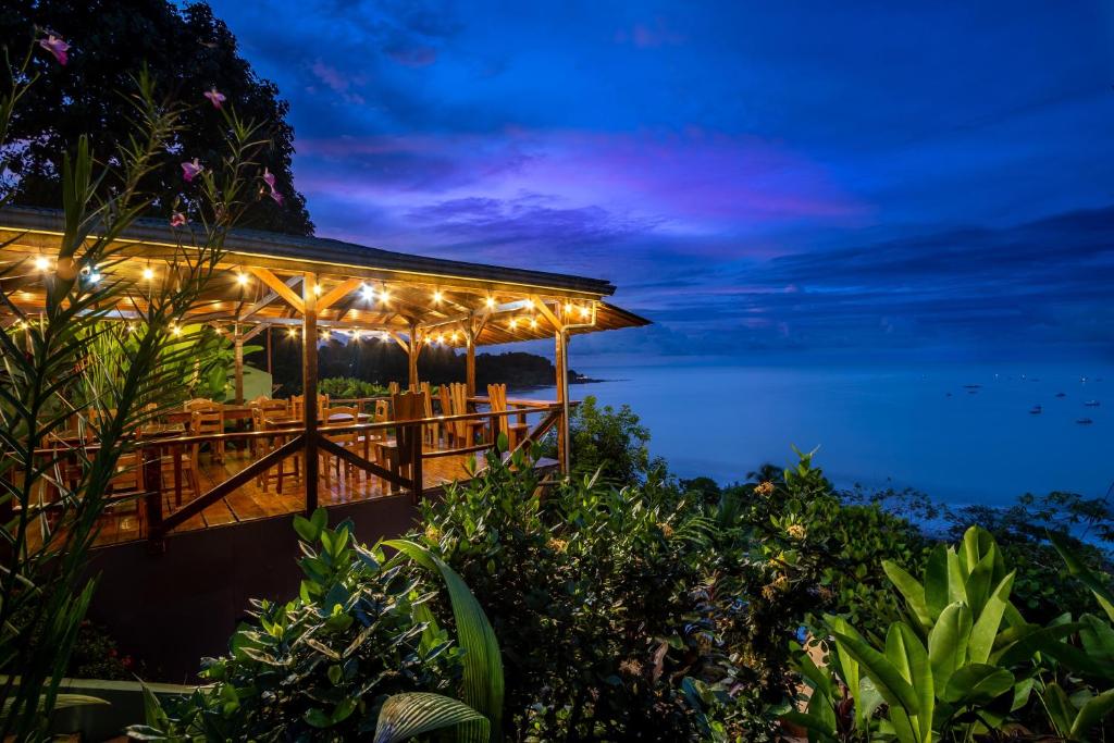 un restaurante con luces encendidas por la noche en Las Cotingas Ocean View, en Drake