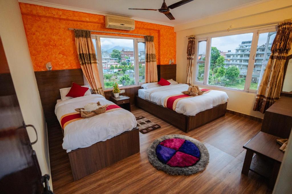a hotel room with two beds and a window at Hotel Himalayan Inn in Pokhara