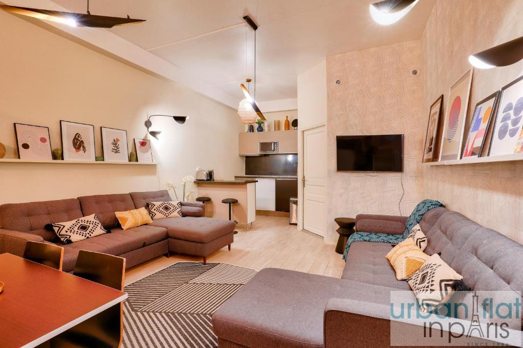 a living room with a couch and a tv at 33 - Flat Av des Champs-Élysées in Paris