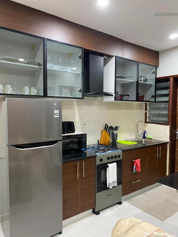 una cocina con electrodomésticos de acero inoxidable y armarios de madera en Aquaview Apartments, en Bijilo