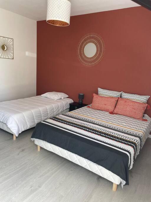 two beds sitting next to each other in a room at Les Chalets du Mancel : Studio June - 24H du Mans - Bouleries Jump - in Parence