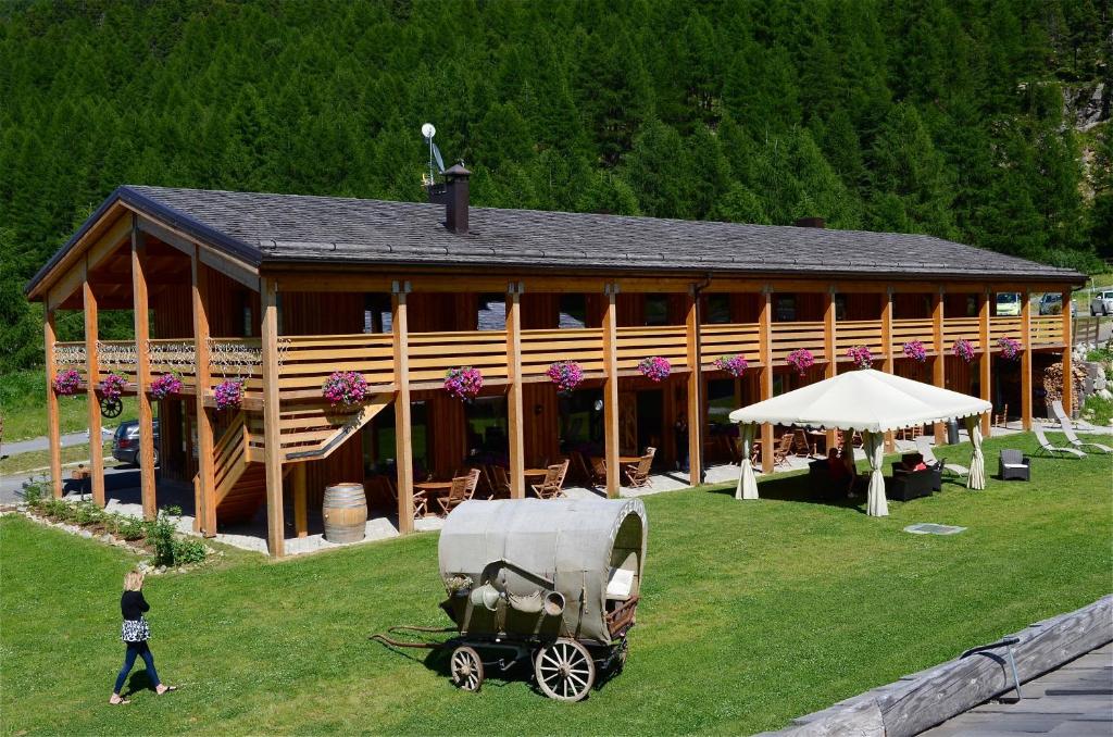 a building with a horse drawn carriage in front of it at La Tresenda Hotel and Mountain Farm in Livigno
