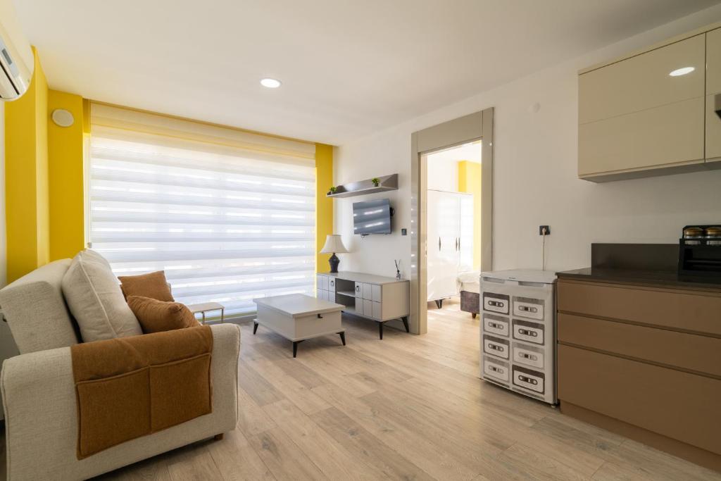 ein Wohnzimmer mit einem Sofa und einer Küche in der Unterkunft Comfy Residence Flat 3 min to Mall of Antalya in Antalya