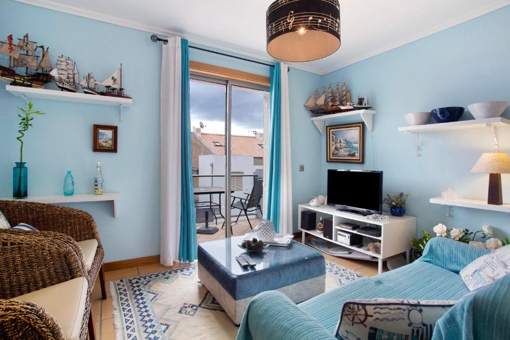een woonkamer met een bank en een tv bij Sun and Moon in Porto Santo
