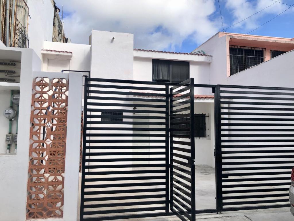 um portão preto em frente a um edifício branco em El Depa del Puerto em Cancún