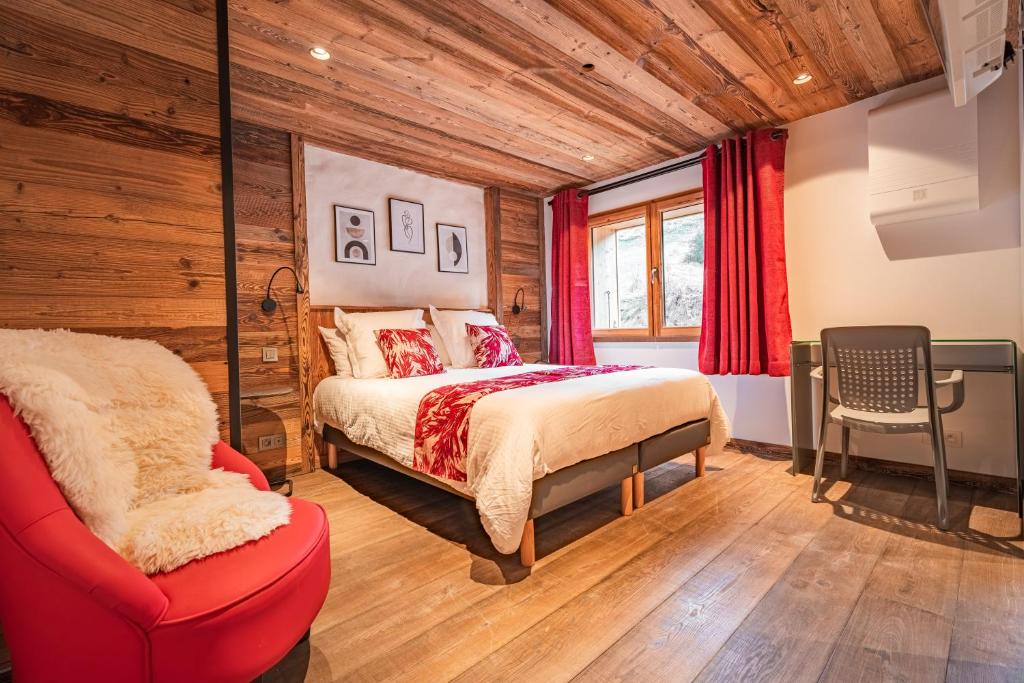 a bedroom with a bed and a red chair at Chalet CHARMING B AND B in Les Gets