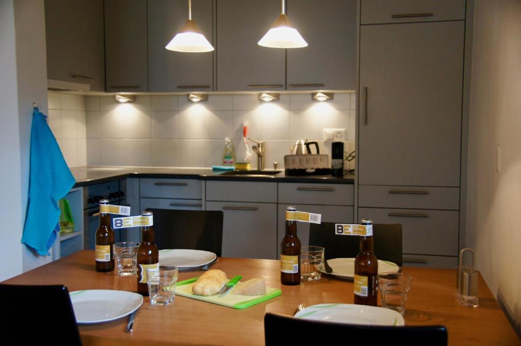 a kitchen with a wooden table with bottles of beer at Chasa Pro La Tuor Pitschna in Ardez