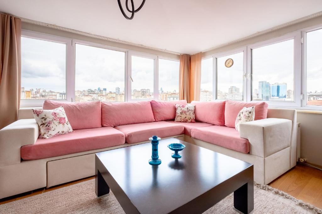 uma sala de estar com um sofá rosa e uma mesa em Flat 7 min to Coast in Suadiye em Istambul