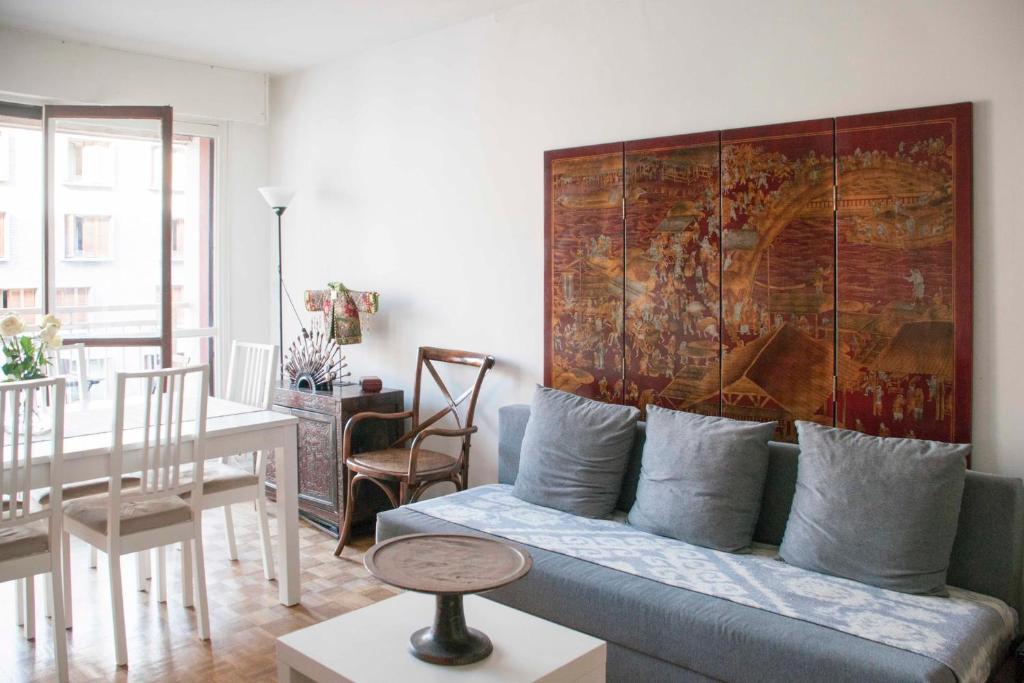 a living room with a couch and a painting on the wall at Modern T3 with Eiffel Tower view in Paris