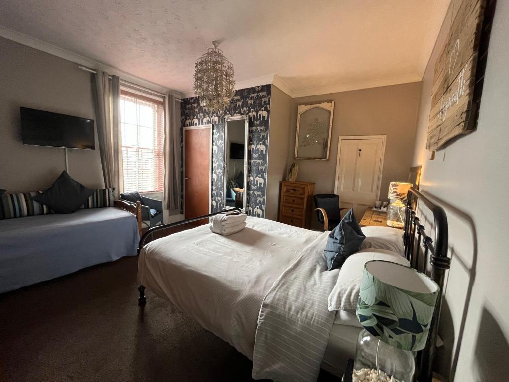 a bedroom with a large white bed in a room at Kelston Guest House in Weymouth