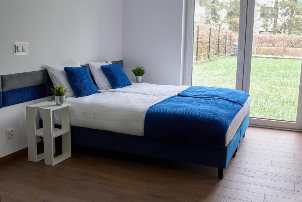 a bedroom with a large bed with blue pillows at Top Loft Znana in Warsaw